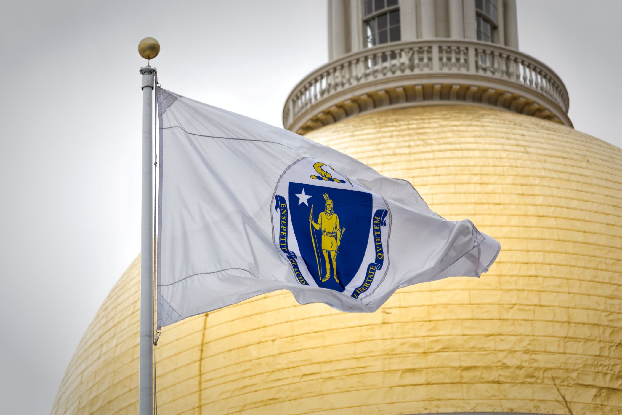Massachusetts State House with legal reference, symbolizing state regulations for insurance requirements