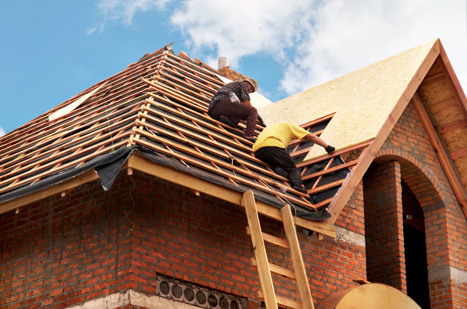 2 roofing professionals working on roof with New Hampshire General Liability Insurance