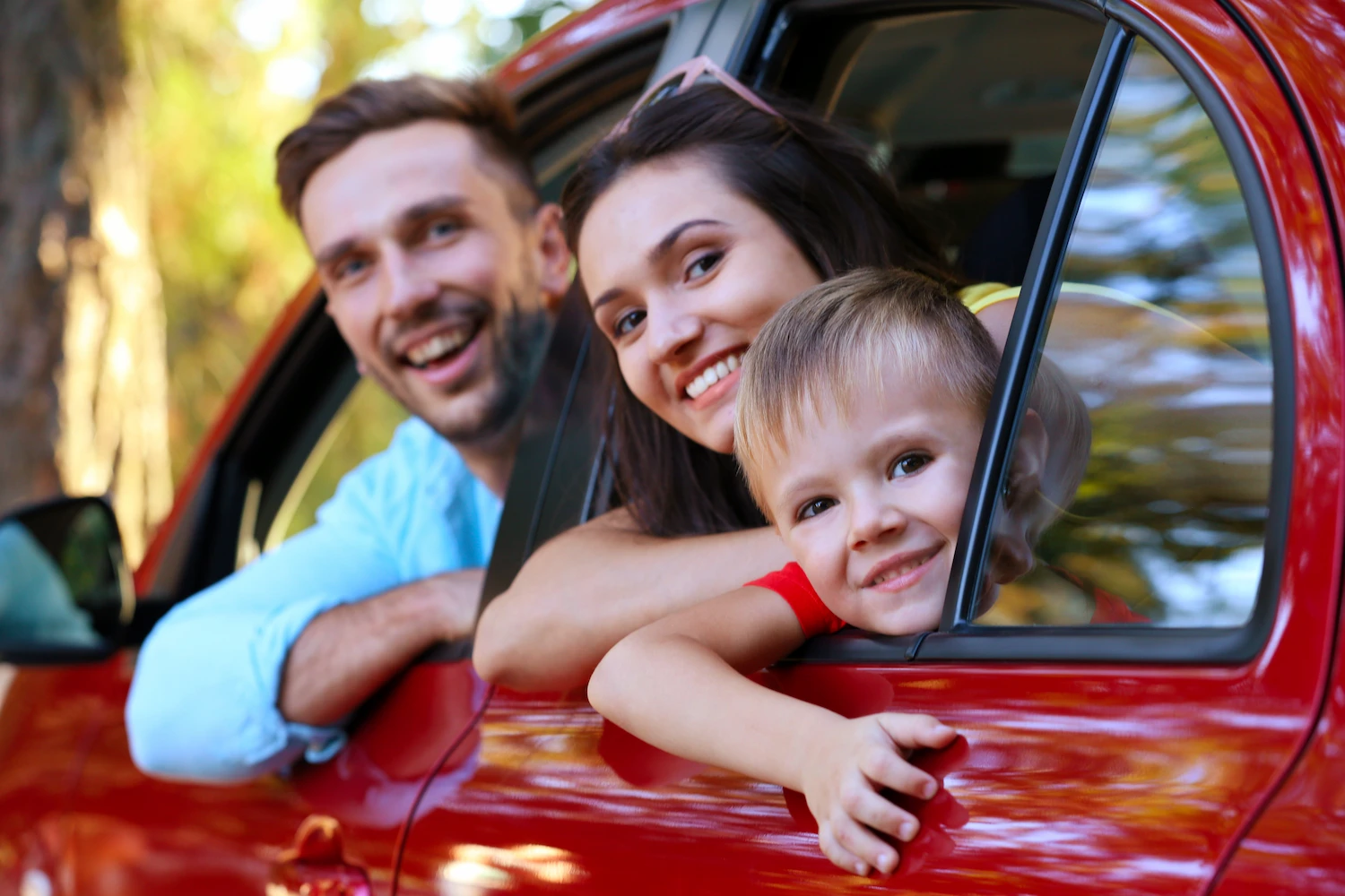 happy family with personnel auto insurance looking out their car windows