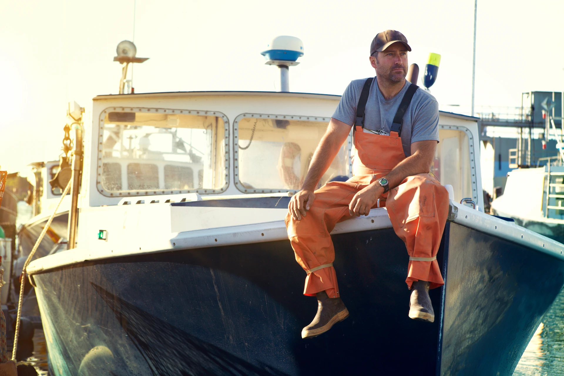 Fisherman sitting on bow of his boat