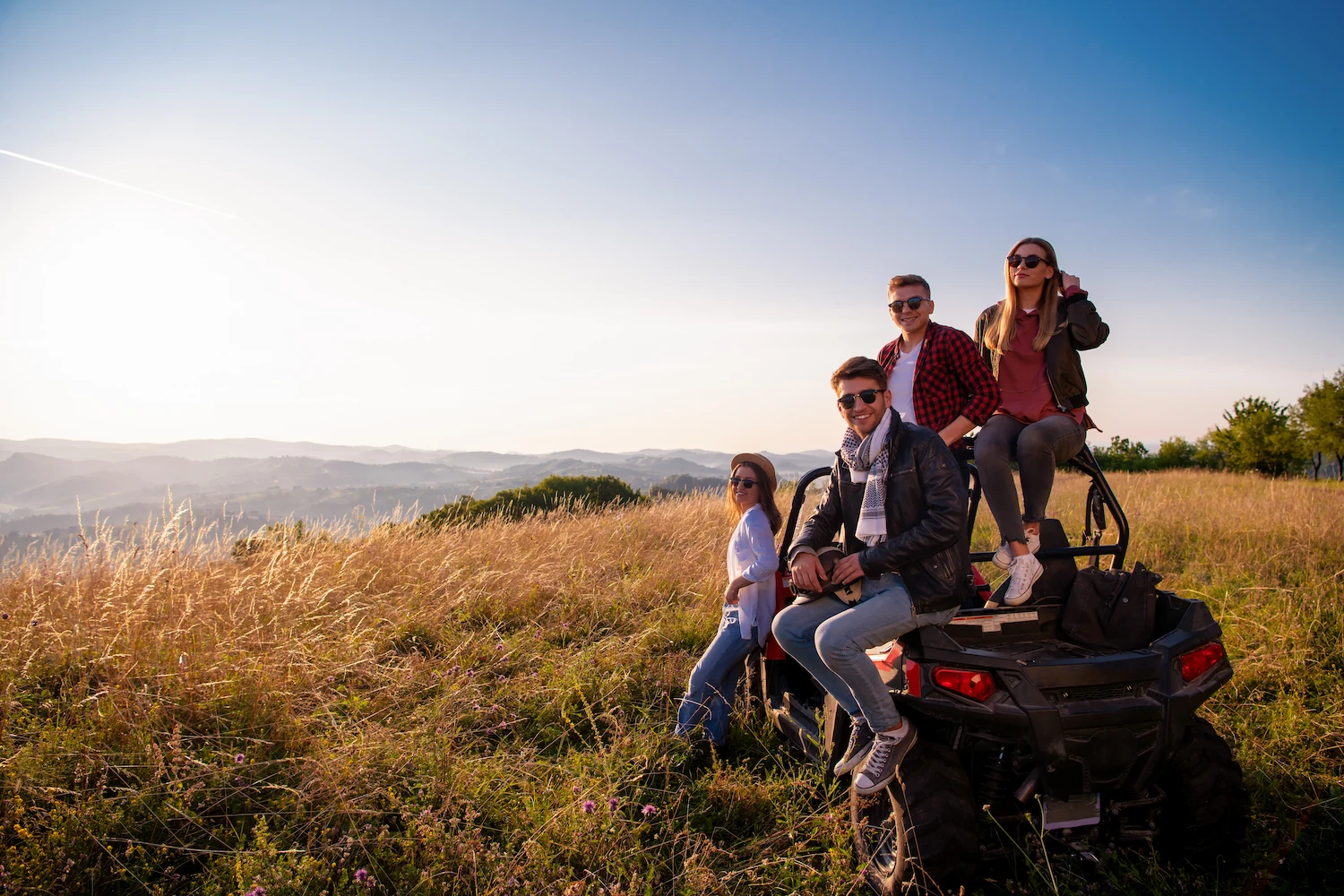 friends posing on a gator 4 wheeler overlooking Vermont