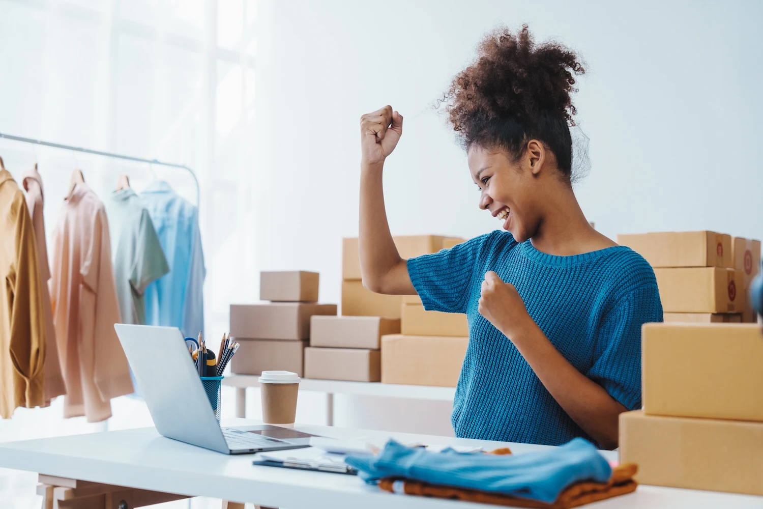 a happy business owner pumping her fist in the air